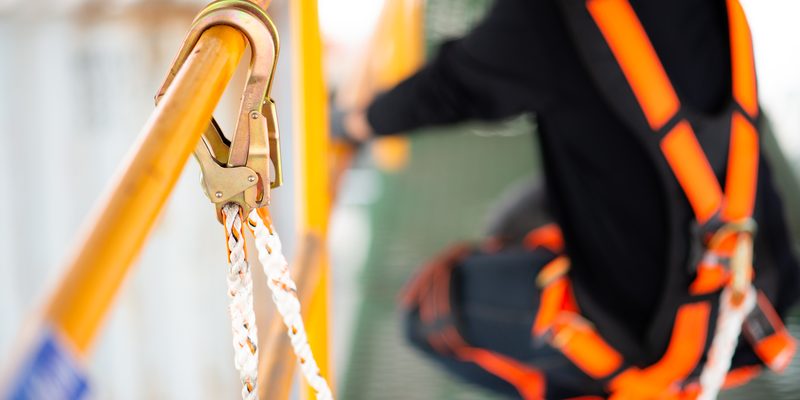 Construction worker wearing safety harness and safety line worki